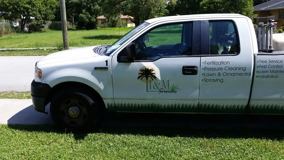 The I&M Services truck with the palm tree logo on the door